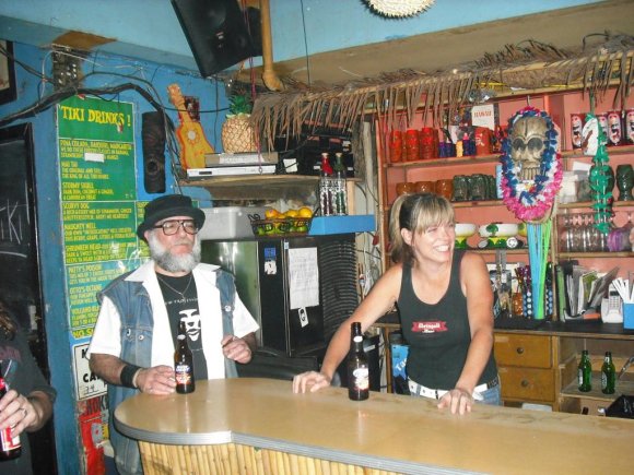 Mr. WOOD watches as LANI holds down the bar.