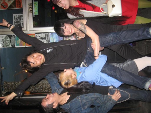 WAKAME & MAKI lift HIRO as he wears a FRANK WOOD shirt and HIROMU (THE UNDEAD) & SATOMI watch and laugh.