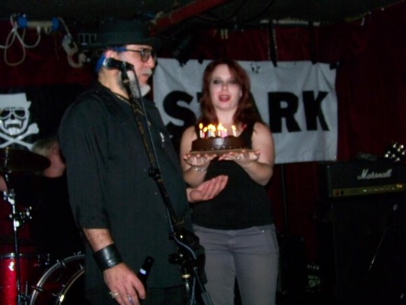 TINA holds the cake while Mr. WOOD makes a wish.