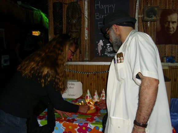 Mr. WOOD looks on as the CATSPAW's gift cake is being lit.