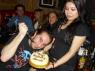 FRANKIE the KID prepares to cut the cake as STEFANY trys not to drop it.