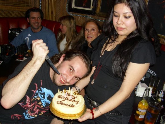 FRANKIE the KID prepares to cut the cake as STEFANY trys not to drop it.