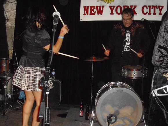 TANIA hitting the cymbals while GREG plays the drums!