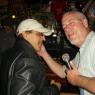 Doorman PAULIE B. trying to resist Owner JOHN's attempt at a Karaoke duet!