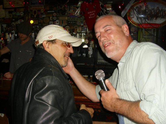 Doorman PAULIE B. trying to resist Owner JOHN's attempt at a Karaoke duet!