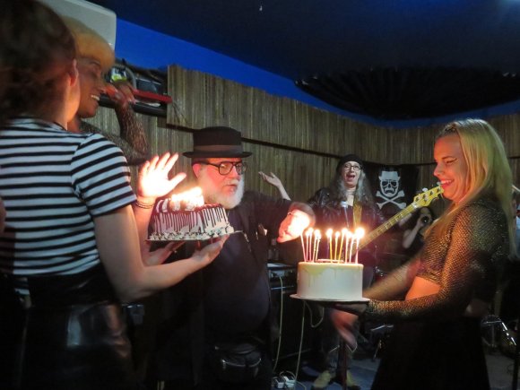 CHRISTA and EMMA Z. bring out the cakes as CYD blocks the A/C as ANNE and JEANNE watch as FRANK accepts the cake!